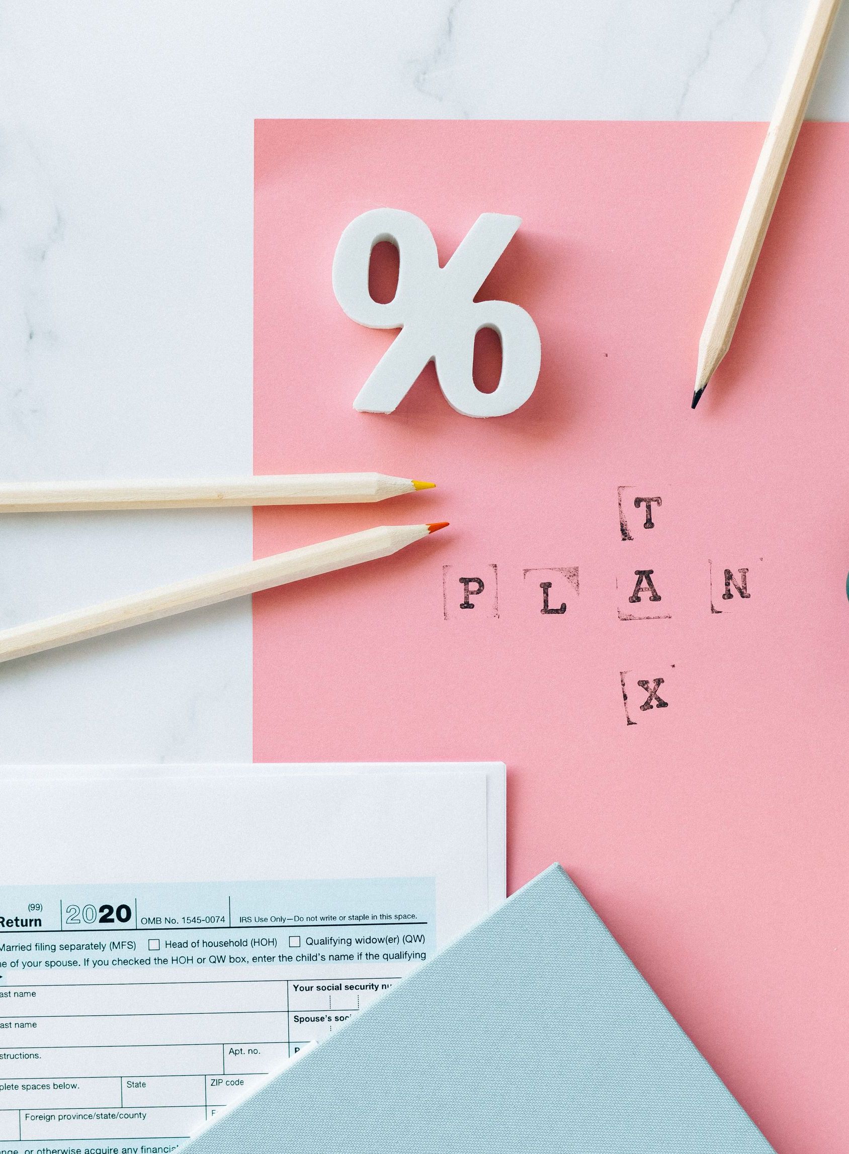Flat lay of tax forms, calendar, and pencils illustrating tax planning.